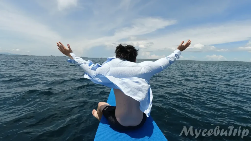 Man enjoying the ocean breeze with open arms on a private boat tour