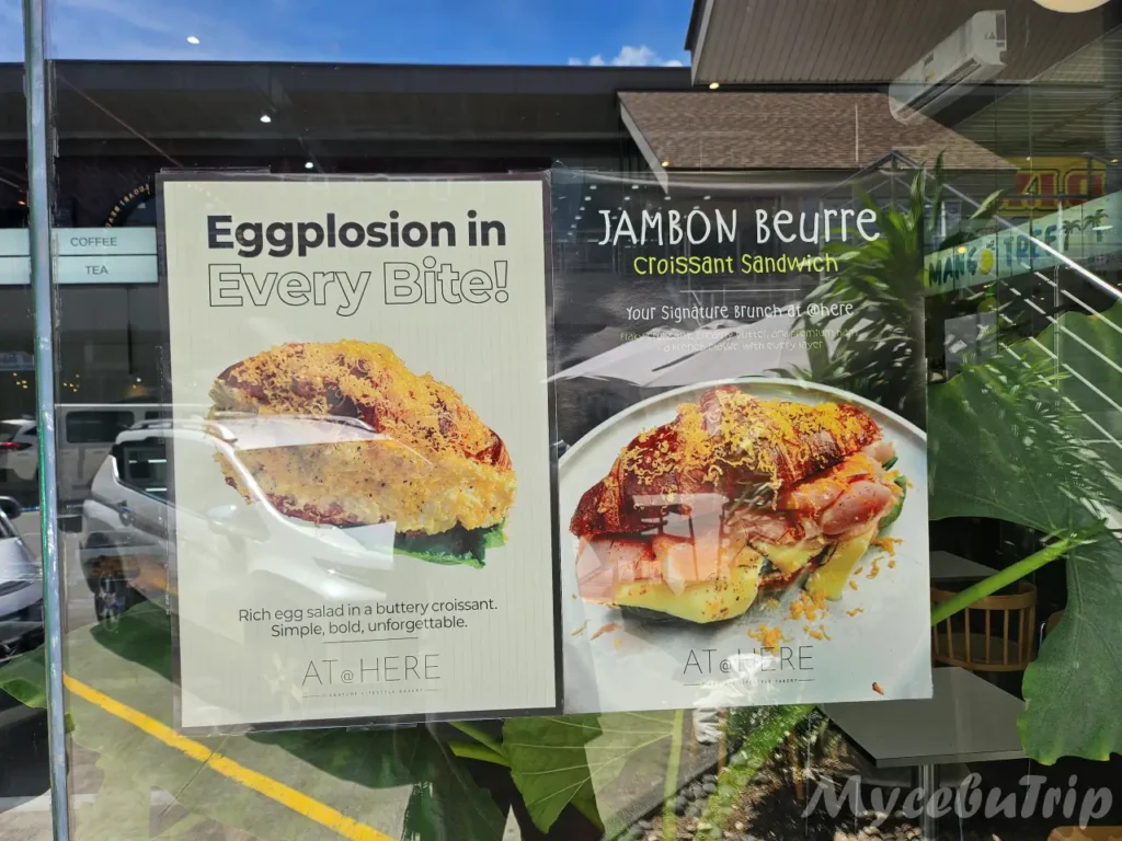 Promotional posters for signature menus Eggplosion and Jambon Beurre Croissant Sandwich at AT@HERE Bakery.