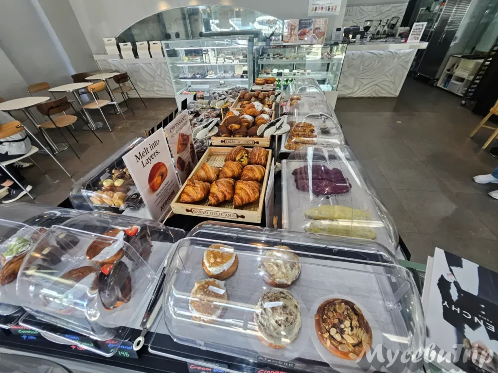 Assortment of freshly baked croissants and Korean-style pastries displayed at AT@HERE Cafe in LG Garden.