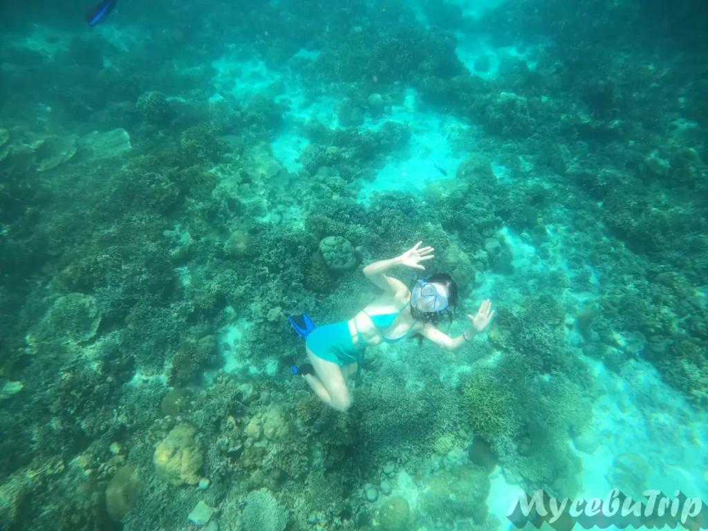 Tourist waving at the camera underwater