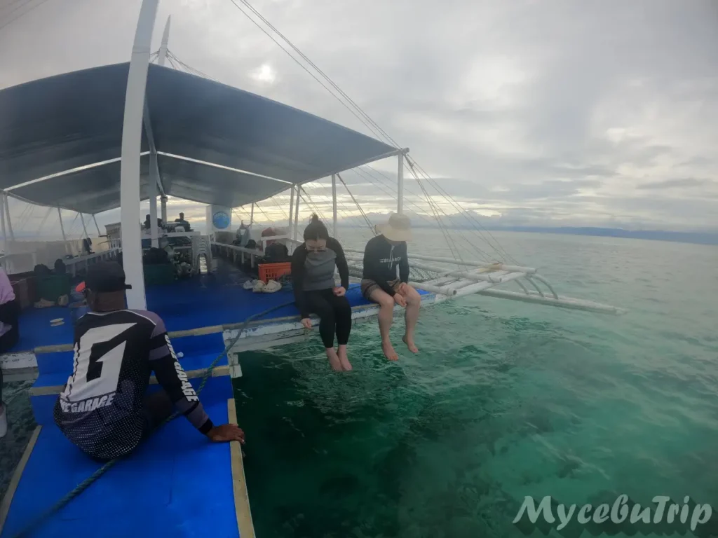 Tourist relaxing on a traditional Banca boat during Cebu island hopping tour