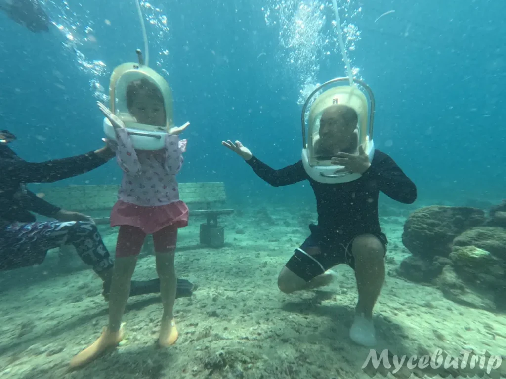 Father and child enjoying a safe underwater walk together with professional guide