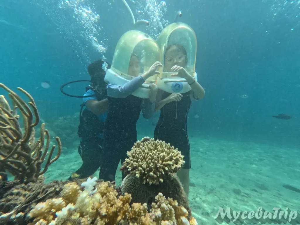 Children making a heart shape together while enjoying safe helmet diving